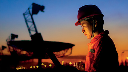 A specialist wearing a hard hat working during sunset, reflecting Bell’s Professional Services that help plan, design and deploy large-scale AI infrastructure.