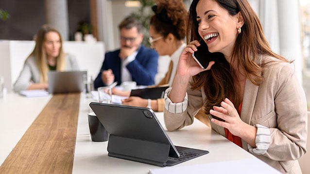 Team collaborating in an office using Bell-provided business devices like smartphones and tablets for increased productivity.