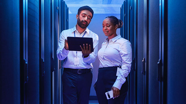 IT managers in a data center use a tablet to streamline device management with Bell's enterprise mobility solutions.