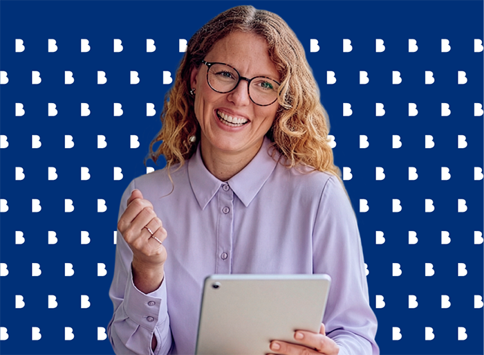 A professional woman holding a tablet and smiling, reading Bell public sector insights.