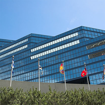 The Calgary Municipal Building with multiple flags in front, representing municipal governments supported by local expertise, modern connectivity, and digital solutions across Canada.